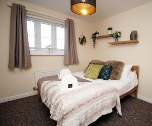 a bedroom with a bed with a teddy bear on it at Sleeps 6 - Argosy Way by Tŷ SA in Newport