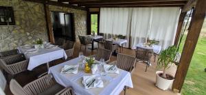 um restaurante com mesas e cadeiras com toalha de mesa branca em Plitvice Inn em Jezerce