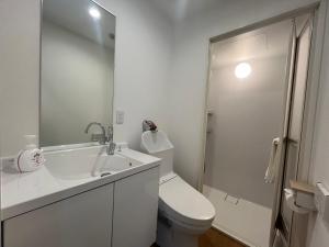a white bathroom with a toilet and a sink at Tokyo Holiday Hotel in Tokyo