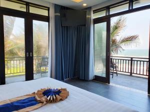 una camera da letto con un letto con vista sull'oceano di Starlight Villa Beach Resort a Phan Thiet Altre 130 foto