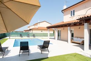 a patio with chairs and a swimming pool in a house at Neue VILLA ROSE Fazana in Pula