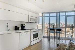 a kitchen with white appliances and a view of a city at Toronto Premier INN in Toronto