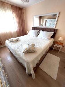 a bedroom with a bed with white sheets and a mirror at Apartment La Casa - Sebenico in Šibenik