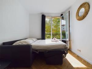 een klein bed in een kamer met een raam bij Cozy Studio vue Parc in Rueil-Malmaison