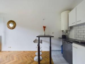 een keuken met een tafel in het midden van een kamer bij Cozy Studio vue Parc in Rueil-Malmaison