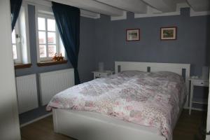 um quarto com uma cama com um edredão rosa em Eulennest em Lauterbach