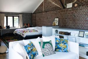 a living room with a white couch and a brick wall at Loft L'Écluse 1, parking gratuit in Saint-Valéry-sur-Somme