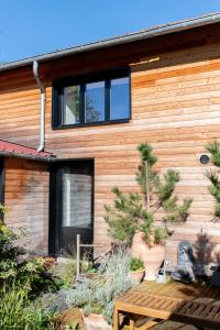 a house with a wooden facade with plants in front of it at Loft L'Écluse 1, parking gratuit in Saint-Valéry-sur-Somme