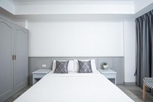 a white bedroom with a large white bed with pillows at Chaipat Hotel in Khon Kaen +46 photos