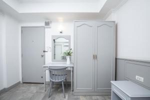 a white kitchen with a table and a mirror at Chaipat Hotel in Khon Kaen