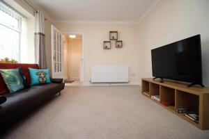 a living room with a couch and a flat screen tv at Keats Retreat by Tŷ SA in Newport