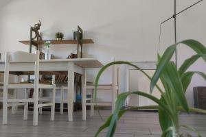 OpenSpace Etna في فياغراندي: غرفة طعام مع طاولة بيضاء وكراسي