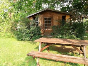 un banc en bois assis devant une petite cabine dans l'établissement OpenSpace Etna, à Viagrande