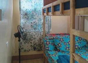 ein Schlafzimmer mit einem Etagenbett und einem Ventilator in der Unterkunft Avong Tako in Baguio City