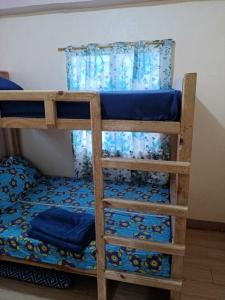 2 Etagenbetten in einem Zimmer mit blauer Bettwäsche in der Unterkunft Avong Tako in Baguio City