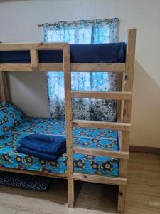 Etagenbett mit blauer Bettwäsche und einer Leiter in der Unterkunft Avong Tako in Baguio City