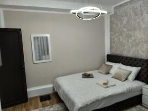 ein Schlafzimmer mit einem Bett mit zwei Hüten darauf in der Unterkunft Apartman Tina in Sokobanja