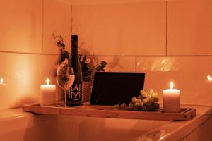 Una mesa con una computadora portátil y velas y una botella de vino. en WohnTraum Refugium, Altstadt, en Meißen