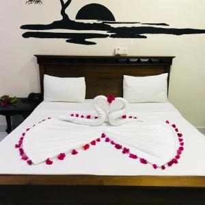 a white bed with a heart made out of flowers at ROYAL GRAND PARADISE RESORT AND TOURS NEAR COLOMBO in Kelaniya