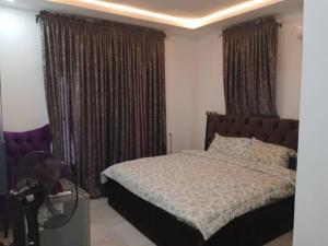 um quarto com uma cama grande e cortinas em Dixonlux Apartments em Abuja