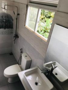 a bathroom with a sink and a toilet and a window at ROYAL GRAND PARADISE RESORT AND TOURS NEAR COLOMBO in Kelaniya