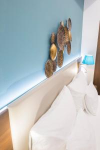 a bedroom with a white bed with shells on the wall at Boutique Apartments Velden in Velden am Wörthersee