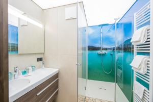 ein Bad mit einer Dusche und einem Waschbecken in der Unterkunft Boutique Apartments Velden in Velden am Wörthersee