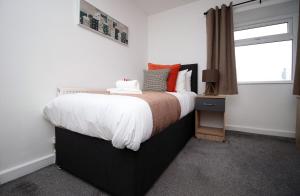 ein Schlafzimmer mit einem großen Bett und einem Fenster in der Unterkunft Kingsway House by Tŷ SA - Spacious 4bed in Newport in Newport