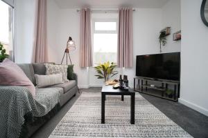 a living room with a couch and a flat screen tv at Kingsway House by Tŷ SA - Spacious 4bed in Newport in Newport