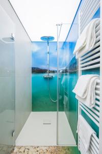 bagno con doccia e vista sull'acqua di Boutique Apartments Velden a Velden am Wörthersee