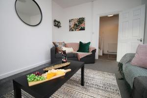 uma sala de estar com uma mesa com comida em Kingsway House by Tŷ SA - Spacious 4bed in Newport em Newport