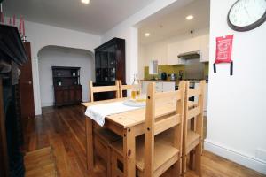 a kitchen with a dining table and a clock on the wall at St Pauls View Apt 2 by Tŷ SA in Newport