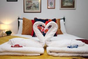 two swans made out of towels on a bed at Flora Suites by Tŷ SA in Newport