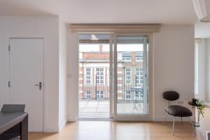 an empty living room with a large sliding glass door at GuestReady - London Urban Retreat at East End in London