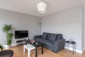 a living room with a couch and a tv at GuestReady - London Urban Retreat at East End in London