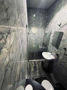 a bathroom with a sink and a toilet and a shower at Sweet Serenity with Lagos View in Lagos
