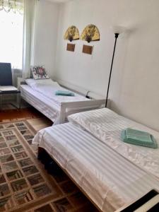 2 camas individuales en una habitación con sofá en China-Ferienzimmer, en Berchtesgaden