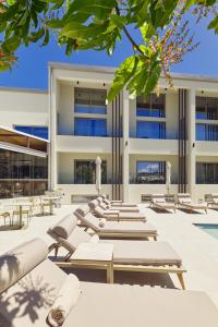 a row of lounge chairs in front of a building at Inea Sole Hotel in Kato Daratso