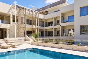 an exterior view of a building with a swimming pool at Inea Sole Hotel in Kato Daratso