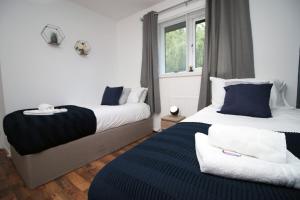 a bedroom with two beds and a window at Langstone Close by Tŷ SA in Llanwern