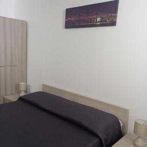 una camera da letto con un letto e un quadro sul muro di Casa Nicotera a Noto Altre 29 foto
