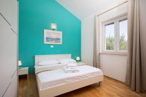 una camera con due letti e una parete blu di Villa Fosca, beautiful villa in a fantastic location a Svetvinčenat (Sanvincenti)