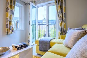 a living room with a yellow couch and a window at Stadium Way by Tŷ SA -Cardiff Central with Parking in Cardiff
