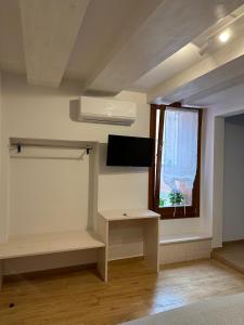 um quarto com uma secretária e uma janela com uma televisão em Sora al Ponte em Chioggia