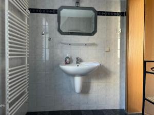 baño con lavabo y TV en la pared en Villa Victoria mit Meerblick, en Sassnitz