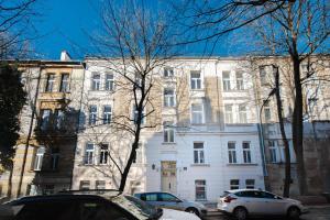 Copernicus House في كراكوف: مبنى أبيض كبير تصطف السيارات أمامه