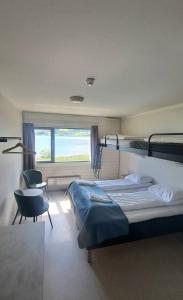 1 Schlafzimmer mit 2 Etagenbetten und einem Stuhl in der Unterkunft Voss Vandrarheim Hostel in Vossevangen