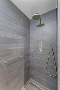 La salle de bains est pourvue d'une douche avec du carrelage gris. dans l'établissement Studio Deluxe 2 Pers Punt West with lake view in Ouddorp, à Ouddorp