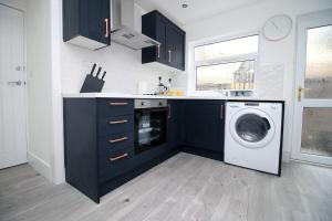 a kitchen with a washer and a washing machine at Station Terrace by Tŷ SA - 3 Bed in Mountain Ash in Quakers Yard
