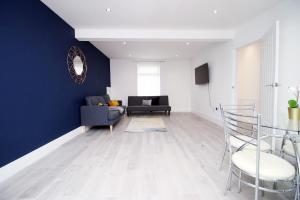 a living room with a blue accent wall at Station Terrace by Tŷ SA - 3 Bed in Mountain Ash in Quakers Yard